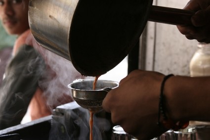 Street vendor straining a pot of Chai Masala
